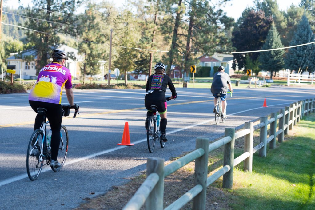 Road cyclists riding single file in bike lane during Spokane Valley Cycle Celebration.