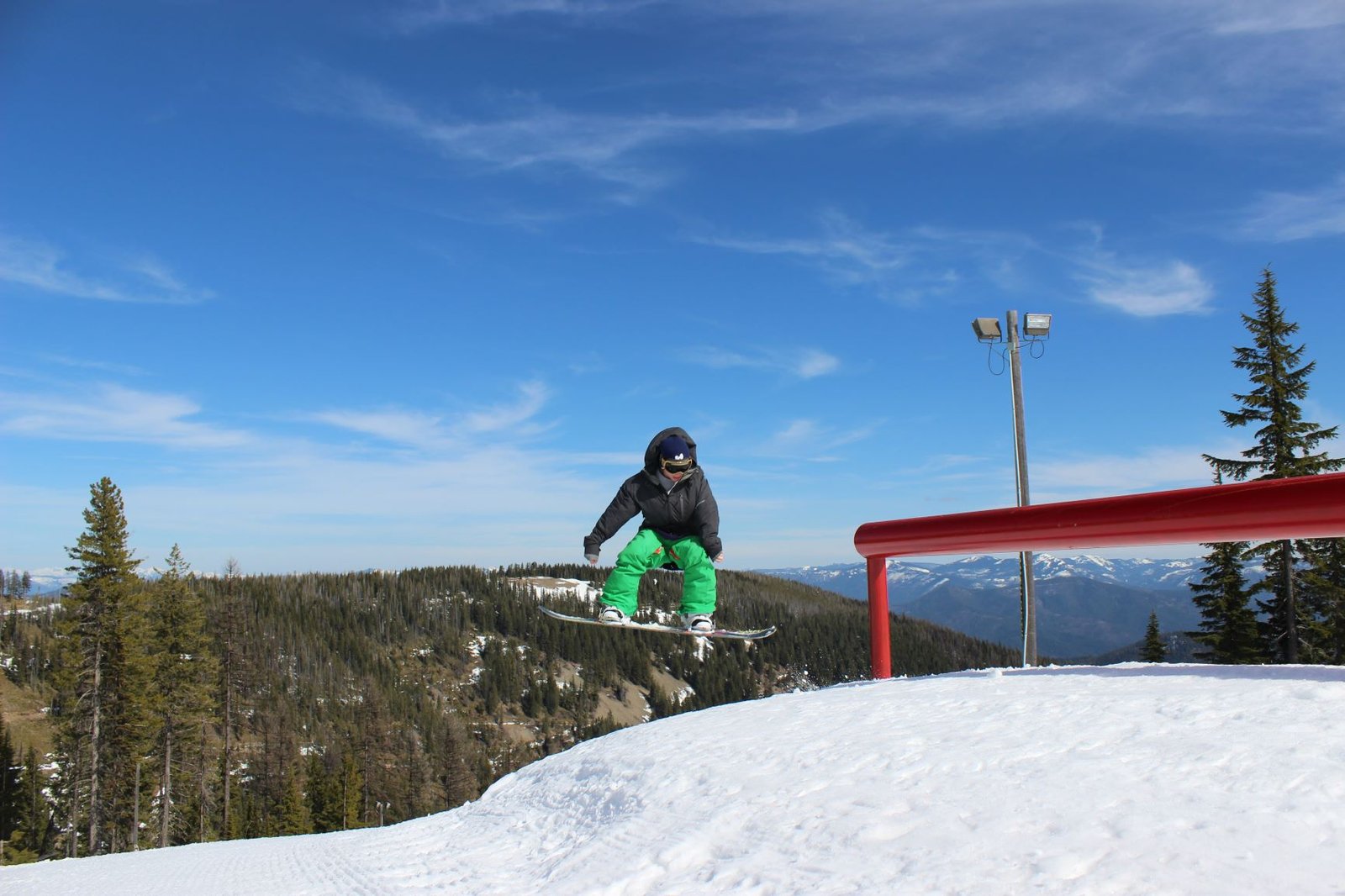 Snowboarder going off a rail in the terrain park at Silver Mountain.
