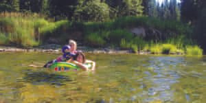 Mom and young daughter floating on a tube down the river.