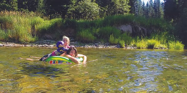 Mom and young daughter floating on a tube down the river.