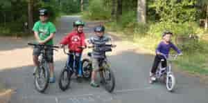 Three boys and girl on their bikes ready to ride the campground loop road.