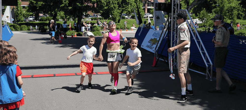 Photo of runner crossing the finish line by Diane Higdem.