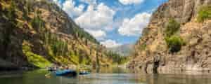 Photo of two rafts with mountains in the background.