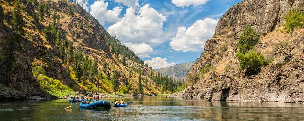 Photo of two rafts with mountains in the background.