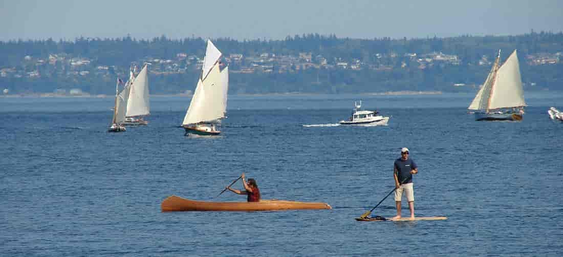Photo of Hari Heath in his paddlecraft with boats in the background in Port Townsend Bay.