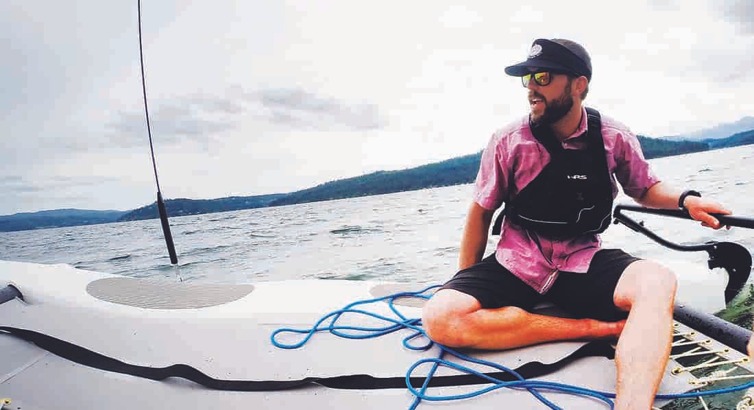 Photo of Jacob Rothrock reclining on a sailcraft on Lake Coeur d'Alene.