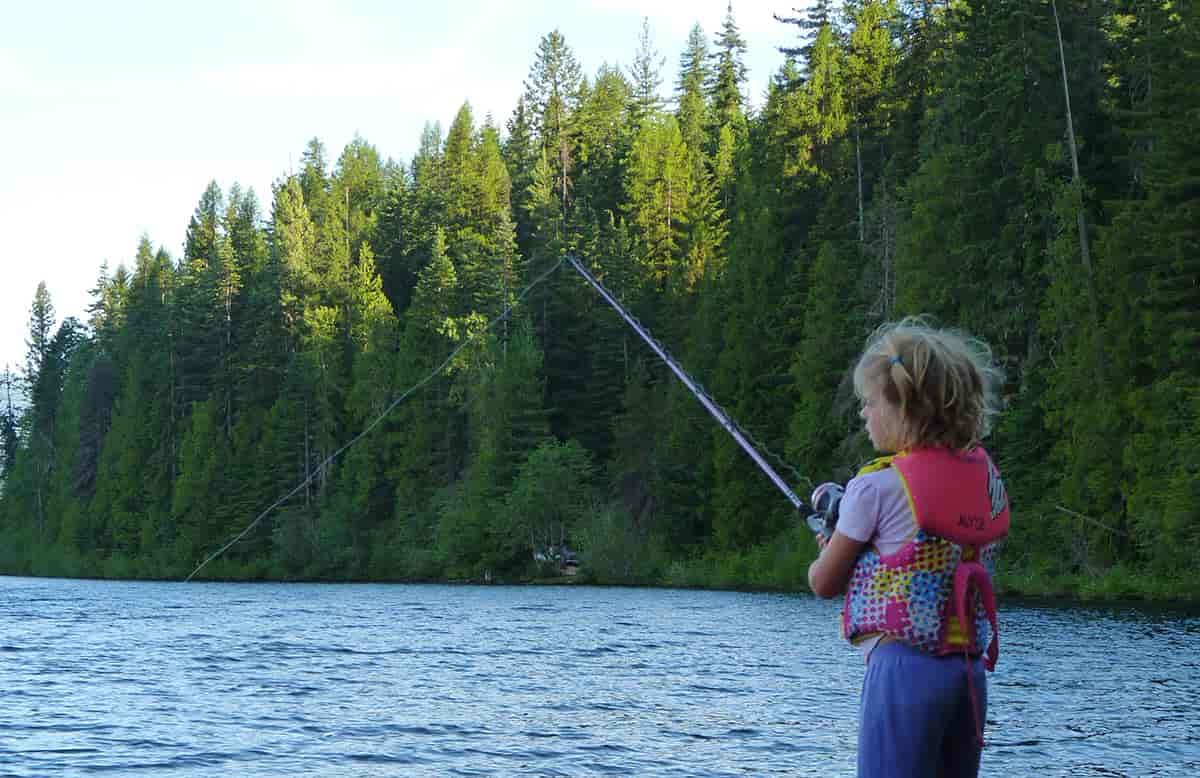 Photo of girl fishing at Priest while standing on a log.