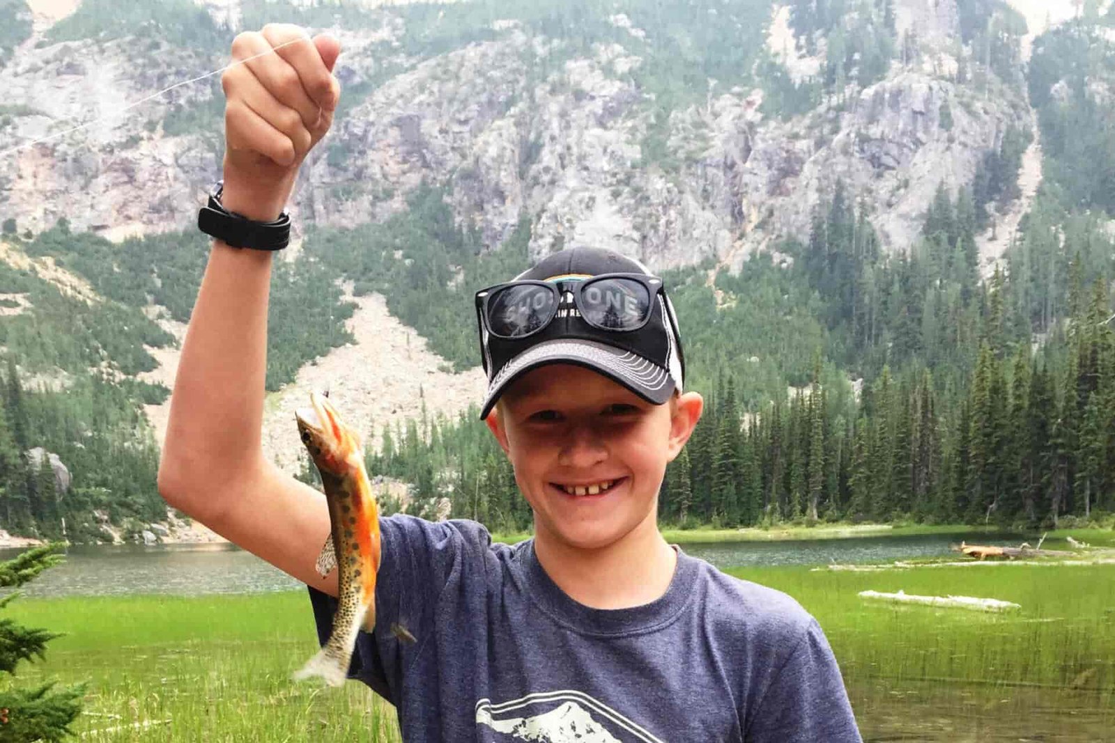 Photo of young boy holding a fish.