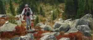 Photo of hiker climbing steep boulder field.