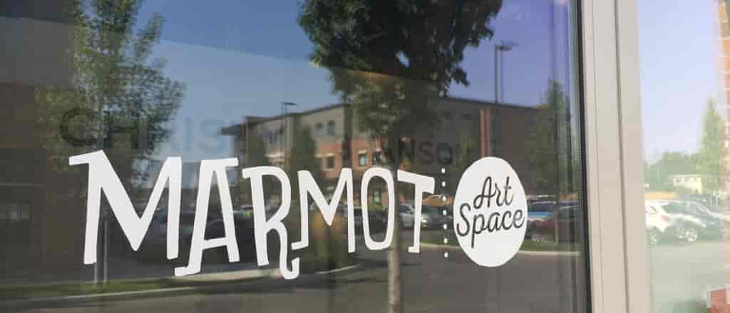 Photo of Marmot vinyl decal on door of gallery.