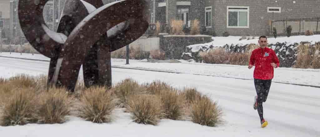Photo of Erik Smith running on the snow covered sidewalk in Kendall Yards.