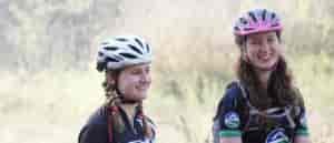 Photo of two girls standing by their bikes.