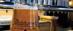 Close up photo of beer with taps in background.