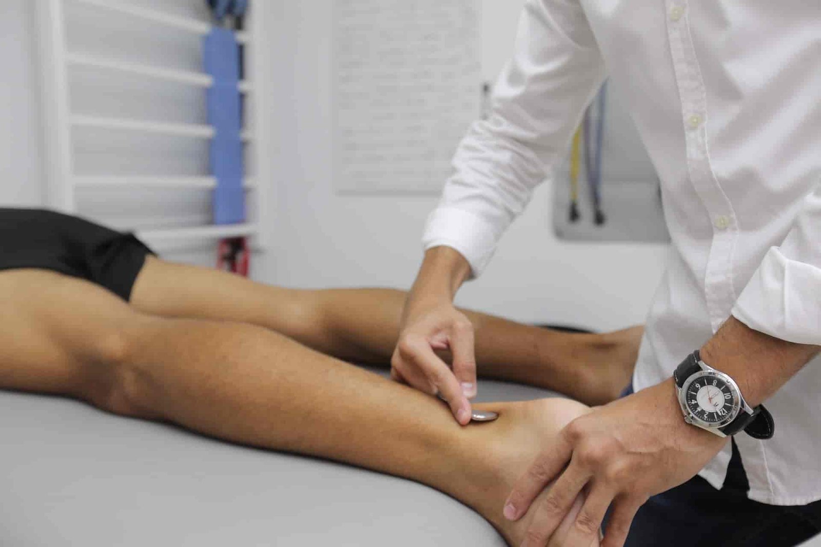 Close up of physical therapist pressing on patient's ankle.