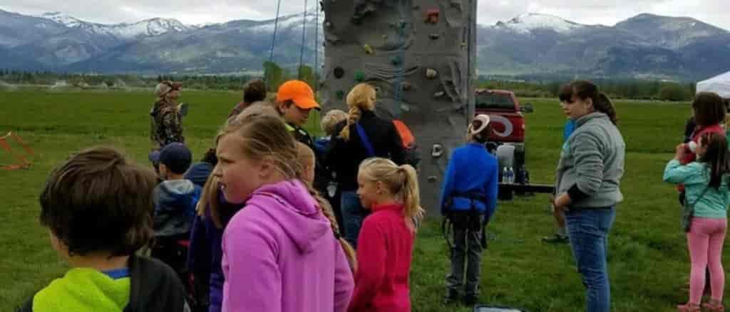 Photo of kids standing around a fiberglass rock wall.