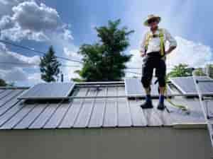 Eco Depot owner and solar installer standing on a roof with solar panels.