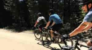 People riding gravel bikes on a dirt road.