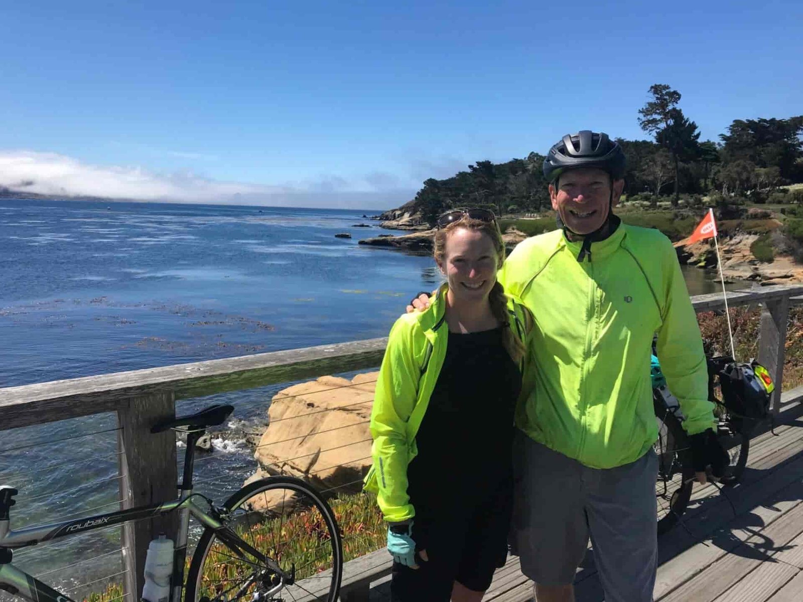 Father and daughter on a bike ride along a lake.
