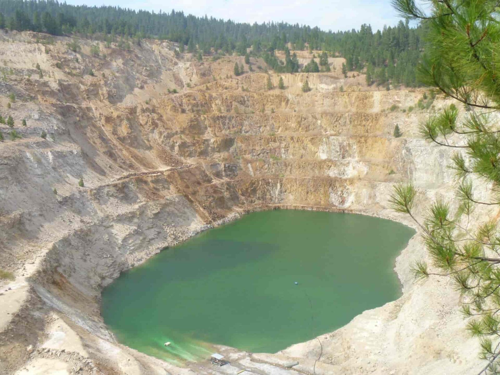 A tan and white mine with green-blue water at the bottom.