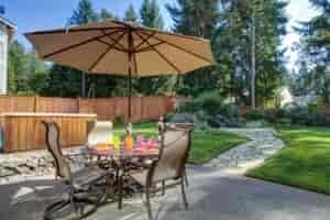Patio furniture with a manicured lawn behind it.