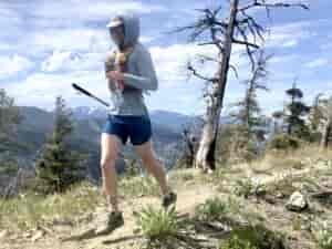 A person running on a mountain trail.