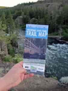 Person holding a brochure with a river in the background.