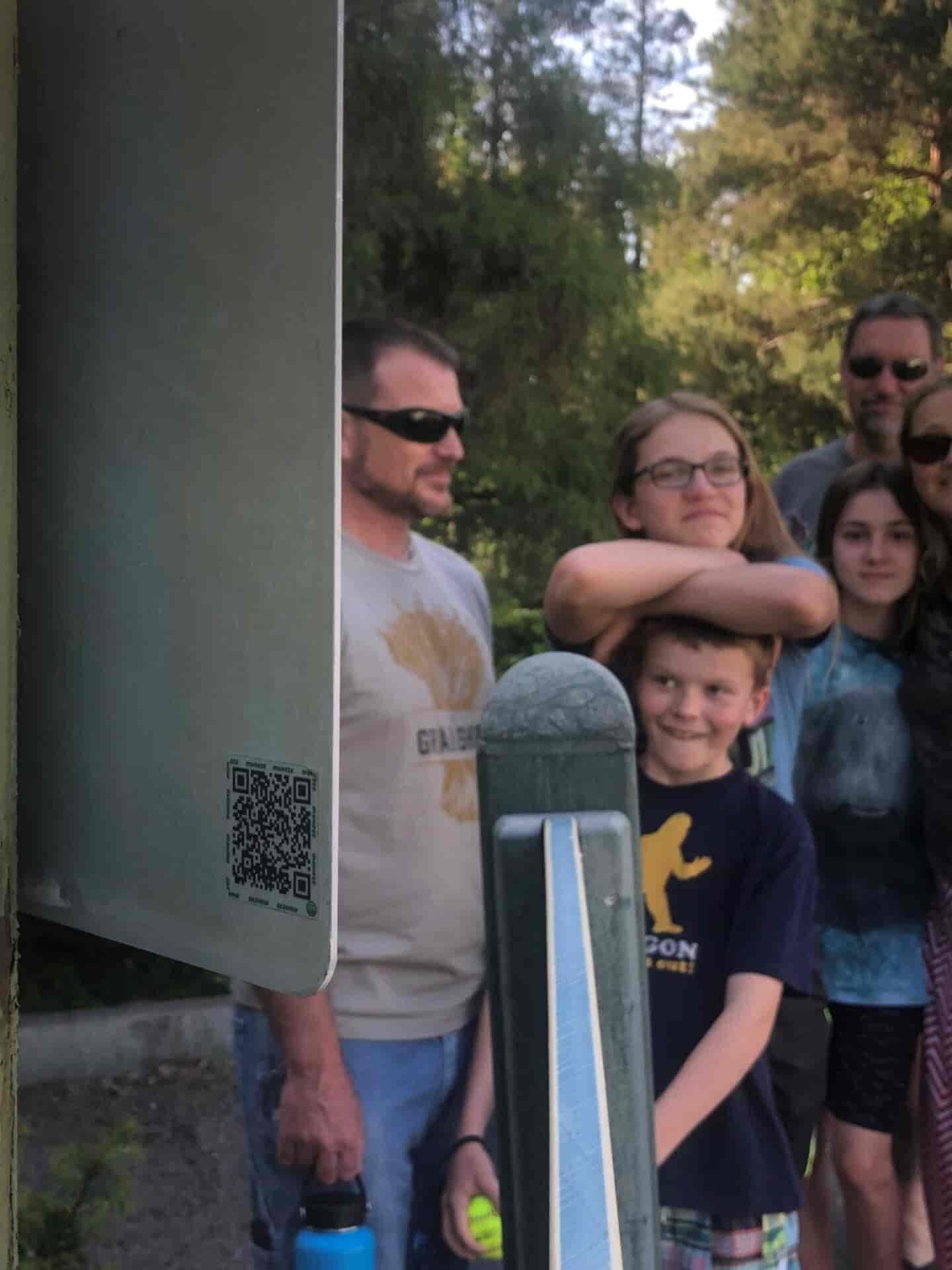 A QR code with a family in the background.