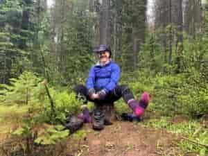 Man with a cowboy hat on and pink socks with no shoes.