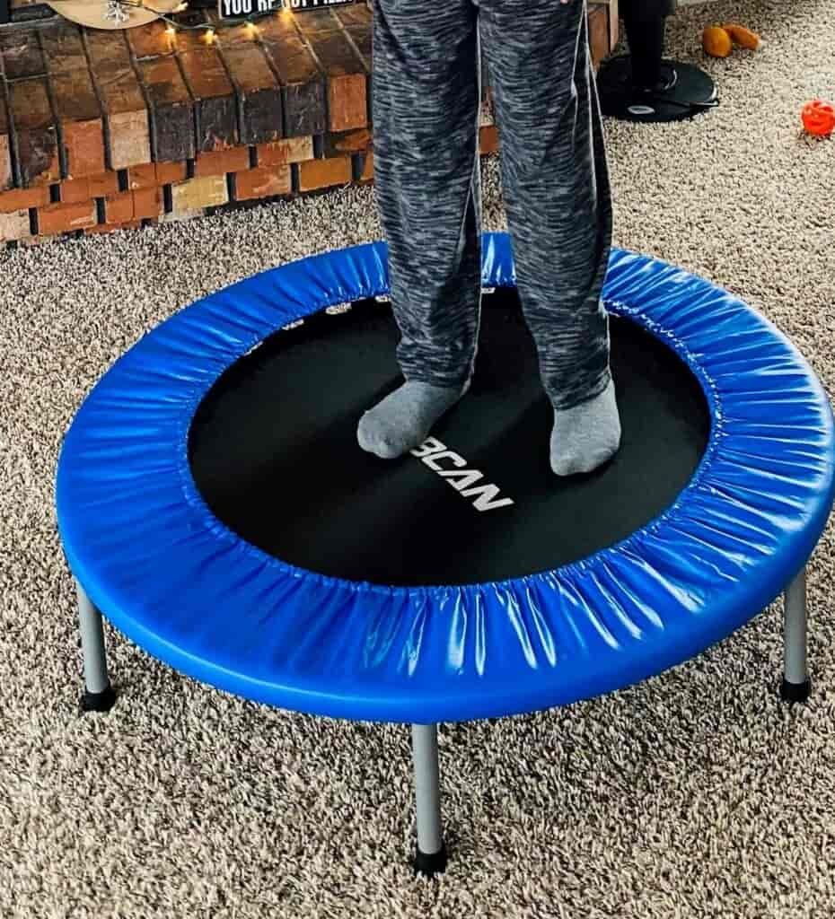 Boy jumping on a mini trampoline close-up.