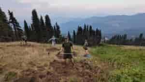 Trail building volunteers holding pulaski tools as they work at Mount Spokane.