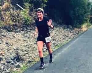 Crystal running in a race and waving and smiling at camera.