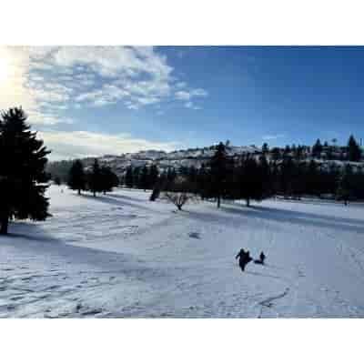 Snowy hill and people tubing.